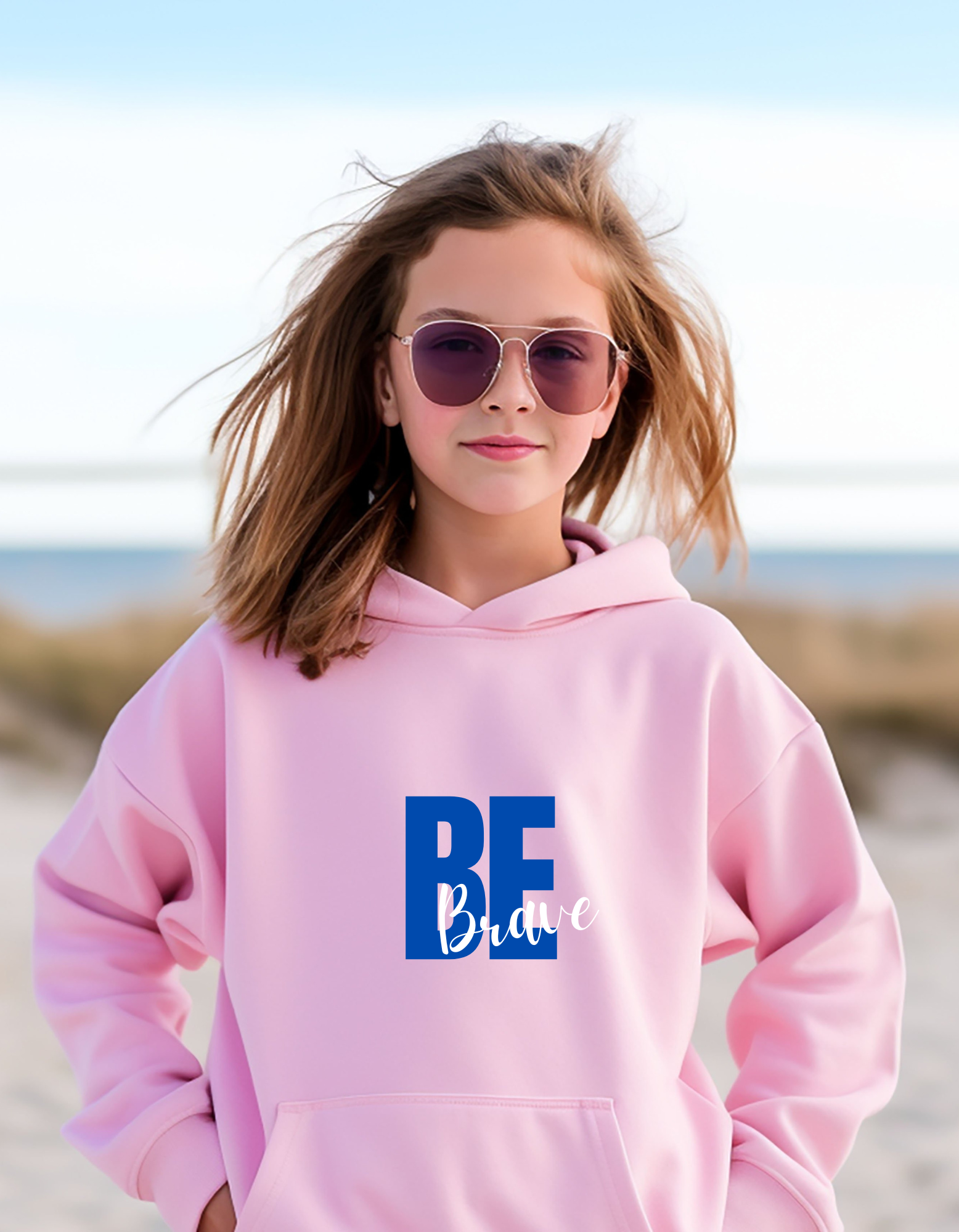 Youth girl wearing pink hoodie with "Be Brave" motivational image on front.