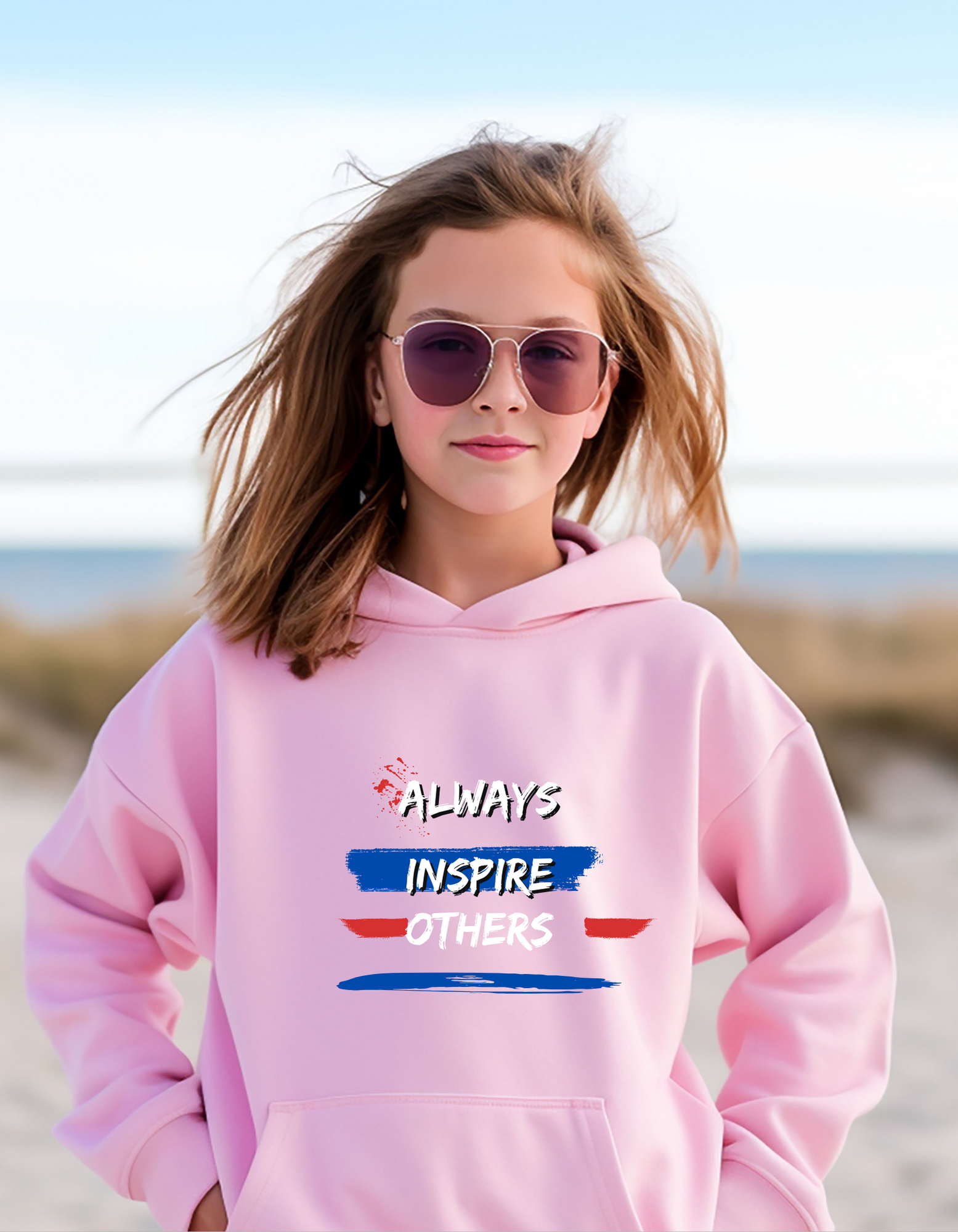 Girl wearing pink hoodie with "Always Inspire Others" motivational image on front.