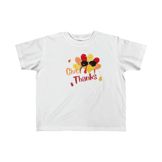 Toddler unisex wearing white T-Shirt " Give Thanks" with Turkey head on front.