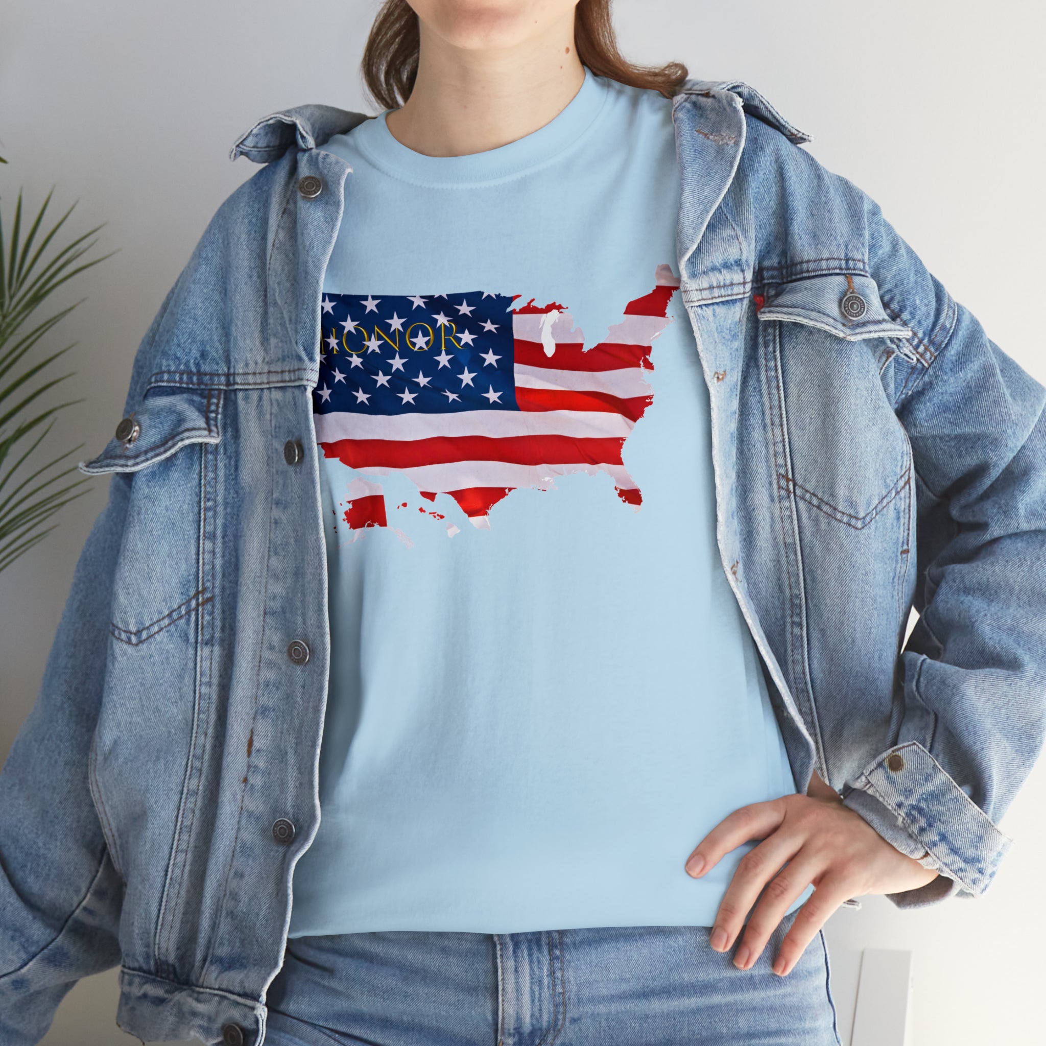 Adult female wearing light blue T-Shirt with "Honor USA" inspired American as a Flag graphic on front, with jean jacket