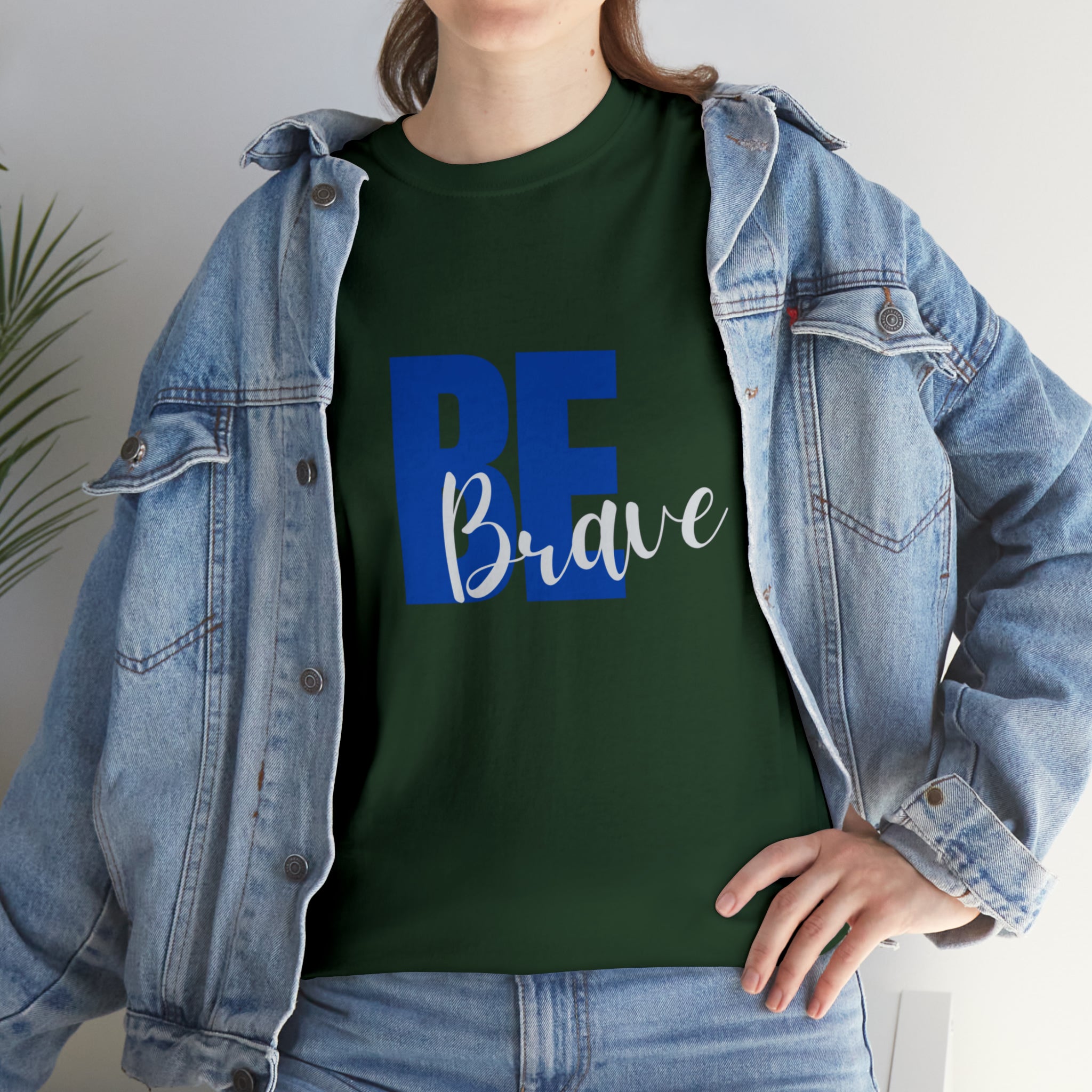 Adult women wearing forest green T-Shirt and Jean jacket with "Be Brave" motivational image on front.