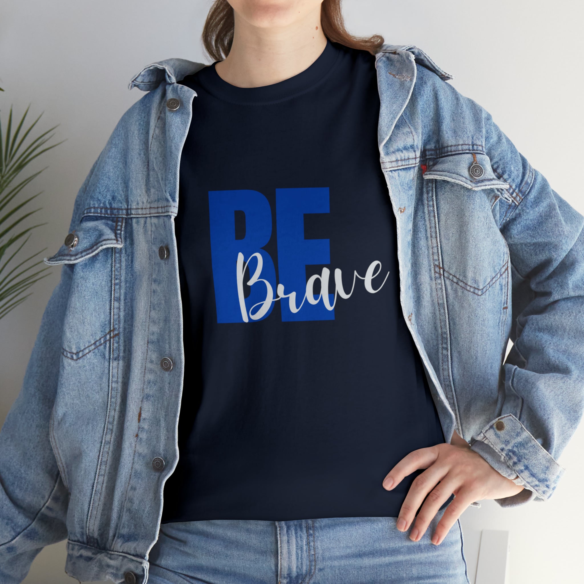 Adult women wearing navy T-Shirt and Jean jacket with "Be Brave" motivational image on front.