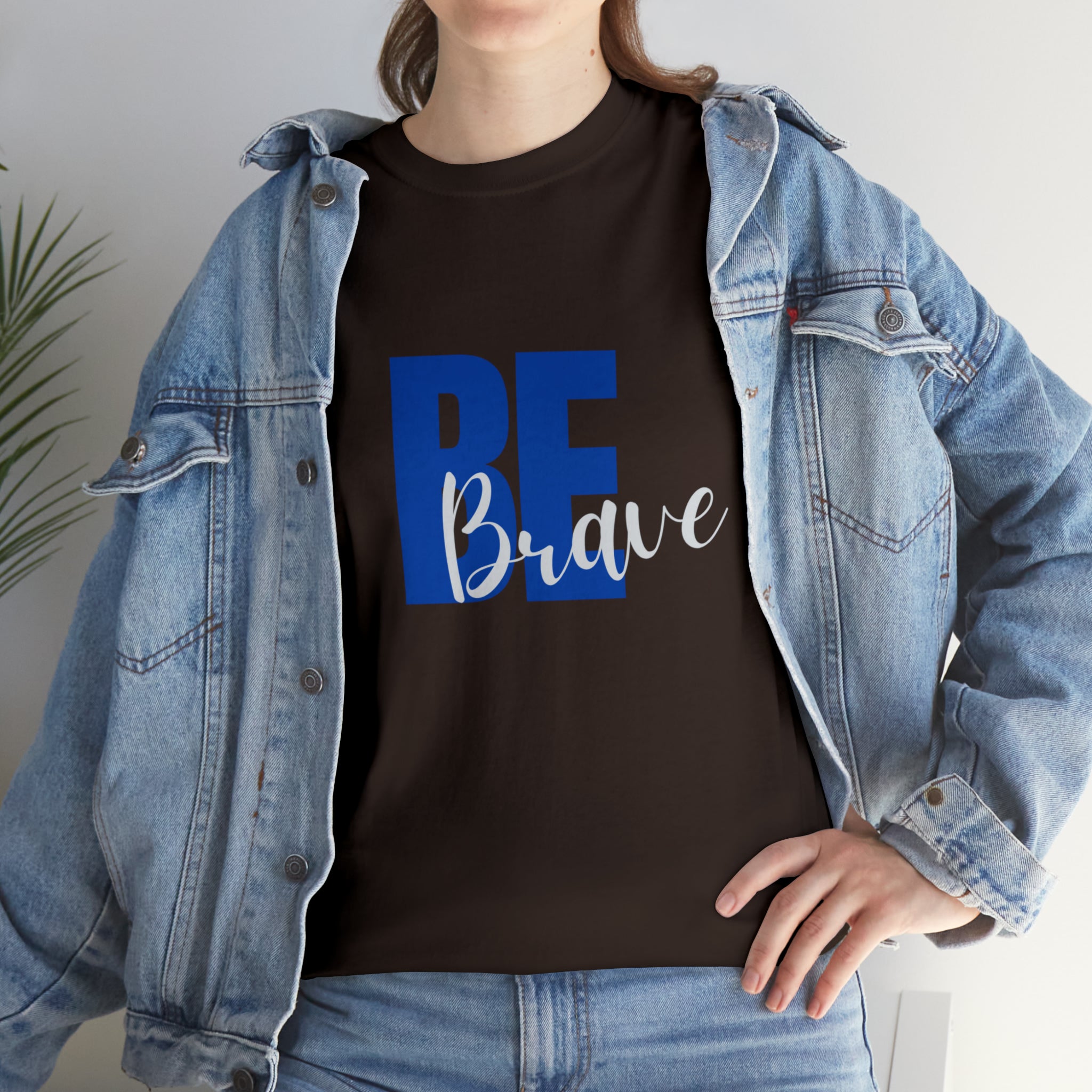 Adult women wearing dark chocolate  T-Shirt and Jean jacket with "Be Brave" motivational image on front.