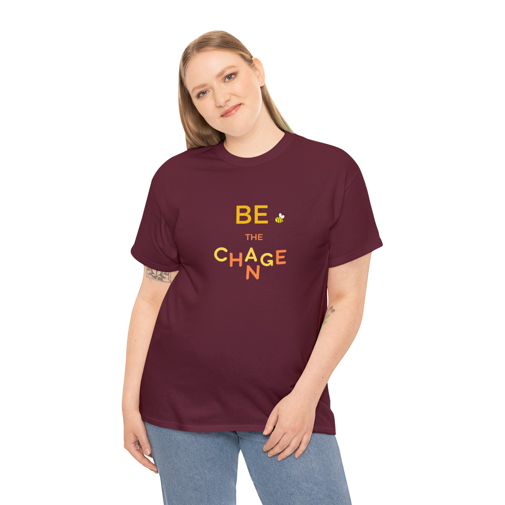 Adult Women wearing maroon T-Shirt with "Be The Change" motivational image on front.