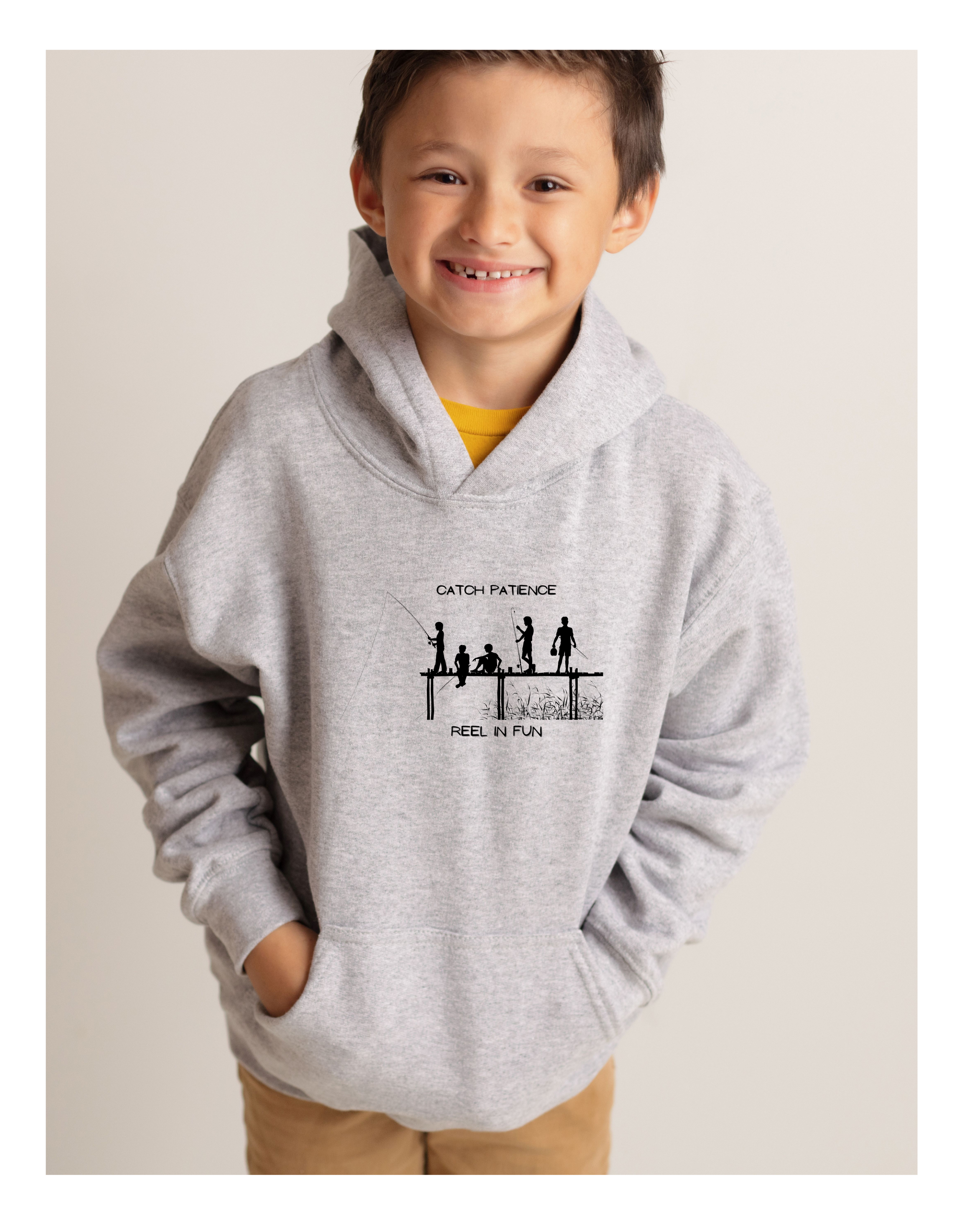 Youth boy  wearing grey hoodie with "Catch Patience Reel in Fun" inspired graphic of people fishing.