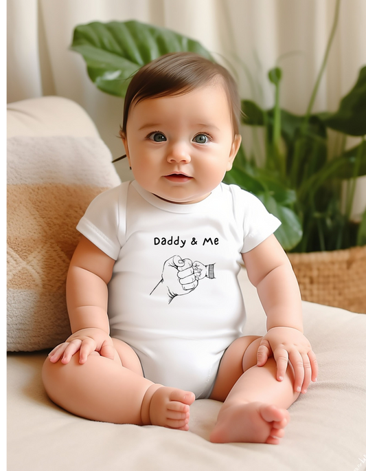 Infant boy wearing white onesie with "Daddy & Me" inspired fist bump graphic on front.